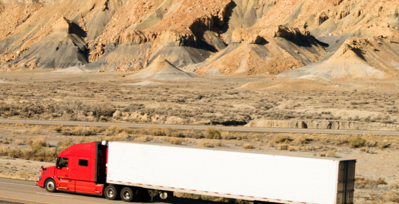 Red 18-Wheeler driving on highway in Texas Desert