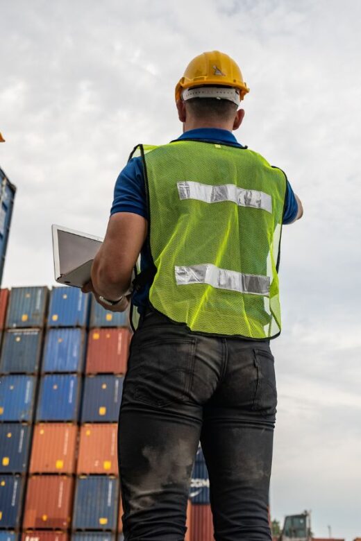 two construction workers looking at cargo